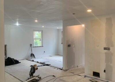 Interior room under renovation with exposed walls and construction materials on the floor.