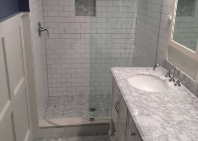 Modern bathroom with a glass-enclosed shower and white vanity.