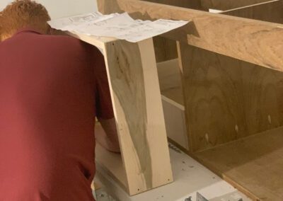 A person reviewing plans while working on a wooden construction project.