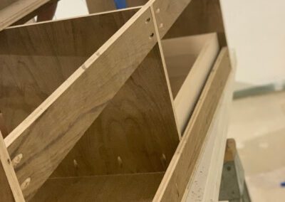 A partially assembled wooden bookshelf with visible shelves and brackets.