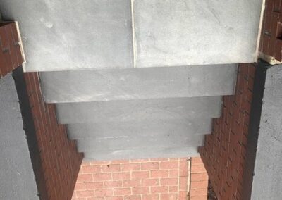 Concrete overhang on a brick wall creating a shadow below.