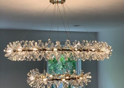 Modern crystal chandelier with gold accents hanging from a ceiling.